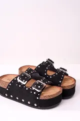 Sandalia de plataforma color negro con dos tiras gruesas con hebillas plateadas y apliques de tachas plateadas.