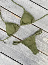 Conjunto de bikini con estampado tie-dye en tonos azul y blanco. El corpiño es de triángulos movibles con tiras para atar al cuello y espalda, y almohadillas desmontables. La bombacha es vedetina con tiritas regulables con hebilla a los costados.