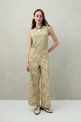 Pantalón ancho de algodón con estampado botánico en tonos verde y beige, corte recto y bolsillos de parche.