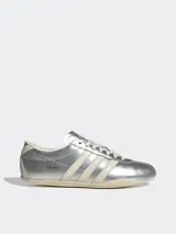 Zapatillas Adidas Tokyo color plateado con las tres tiras laterales en color crema.