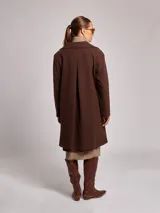 Tapado oversize color chocolate, con cuello de pelaje y diseño de cierre frontal.