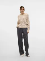 Sweater de punto calado color crema, con cuello redondo y mangas largas.