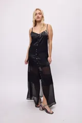 Vestido largo blanco con breteles finos, corte amplio y paneles de encaje.