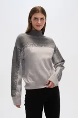 Sweater gris con cuello alto, diseño degradado y apliques de lentejuelas en el frente y las mangas.