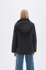 Campera negra con capucha y cuello de piel sintética.