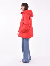 Campera puffer roja con capucha, cierre frontal con cremallera y bolsillos laterales con cierre.