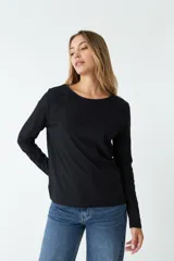 Remera negra de algodón, de corte recto, manga larga y cuello redondo.