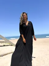 Vestido largo negro con escote en V y mangas 3/4 amplias.