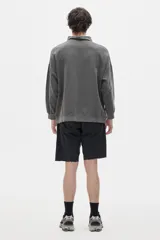 Buzo gris con cuello alto y cierre parcial.