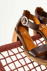 Sandalias de cuero color crudo, con tira ancha sobre los dedos, pulsera con hebilla al tobillo y taco cuadrado de madera.