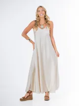 Vestido largo de breteles finos, confeccionado en tela italiana satinada color champagne, de caída suave y amplia.