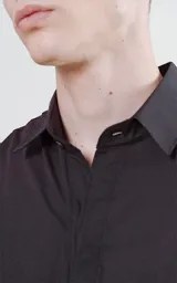 Camisa negra de manga larga con bolsillo ojal en el delantero, cartera escondida y calce oversize.