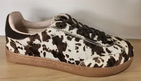 Zapatillas urbanas con estampado animal print en blanco y negro, detalles en gamuza negra y cordones negros. Incluye cordones crudos extra.