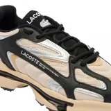 Championes urbanos Lacoste modelo Athleisure L003 2k24, con capellada de malla color beige, detalles en cuero sintético negro y plateado, y suela chunky color beige y negro.