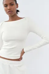 Camiseta negra de algodón con cuello barco y mangas largas.
