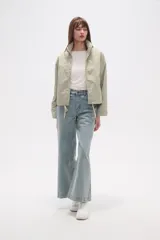 Campera de corte holgado en color tostado, confeccionada en poliamida. Presenta cuello alto, cierre frontal con cremallera, bolsillos laterales con cierre y cordón ajustable en el ruedo.