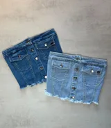 Top strapless de jean celeste con botones plateados al frente y ruedo desflecado.