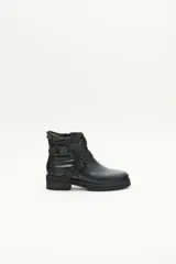 Bota de caña media confeccionada en cuero negro. Diseño rockero con dos tiras cruzadas en el empeine, decoradas con remaches y hebillas metálicas. Laterales matelaseados y cierre lateral interno.
