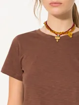 Remera gris confeccionada en algodón pima, de corte recto, con largo a la primera cadera, tajos laterales, mangas cortas y cuello redondo a la base. Detalle de logo 3D en el centro de la espalda.