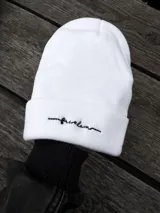 Gorro de lana blanco con bordado de la palabra "freedom" en letra cursiva negra.