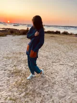 Saco de lana azul con bolsillos de cuero color naranja, botones al frente y tajos a los costados.