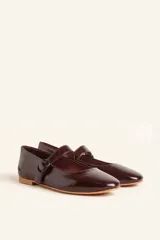 Zapato tipo Mary Jane color borgoña, de charol con correa sobre el empeine y hebilla redonda.