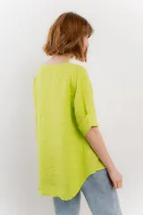 Blusa verde salvia de lino, con escote en V, manga corta y un botón de madera al frente.