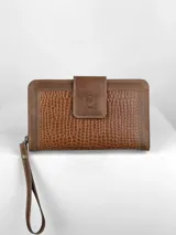 Billetera de dama color marrón, estilo clutch o muñequera, con textura de cuero cocodrilo (crocco) en los paneles laterales y solapa central lisa con logo grabado. Posee una correa de mano desmontable.