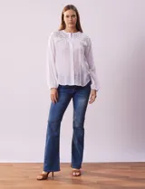 Blusa azul marino de manga larga con cuello redondo con detalle de broderie y cierre frontal con botones.