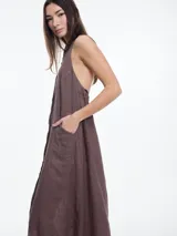 Vestido largo sin mangas confeccionado en lino, color azul, con cuello camisero y espalda descubierta con ajuste regulable.