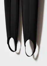 Calza fuseau negra de tejido elástico con costuras decorativas, tiro alto y cintura con goma elástica.