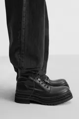 Bota de cuero negra con cordones, caña media y suela track.