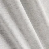 Remera gris jaspeado de manga corta, corte holgado y cuello redondo. Estampado frontal con el logo de New Balance y la leyenda "athletic shoes" en verde.