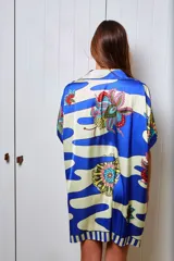 Camisola estampada en seda, con cuello camisero, manga corta y calce holgado. Presenta un diseño con rayas horizontales y flores. Puede usarse como camisa o vestido.