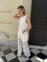 Pantalón de gabardina color crudo con encaje floral blanco en la parte inferior de las piernas.