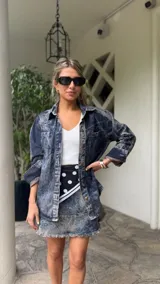 Minifalda de denim celeste con efecto lavado, corte acampanado y ruedo desflecado.