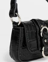 Monedero de cuerina color negro con textura croco, formato bolso con manija desmontable y solapa con broche con botón para cerrado.
