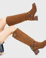 Botas de caña media color marrón de gamuza sintética, con taco cuadrado y plataforma. Presentan hebillas decorativas y ajuste con correa.