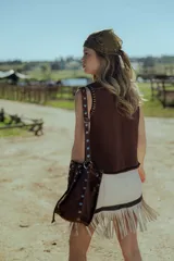 Minifalda marrón de cuero ovino con flecos y cierre frontal.