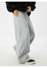 Pantalón de jogging gris de algodón, corte ancho (baggy) y tiro alto, con costura central vertical que recorre la pierna.