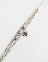 Set de tres pulseras plateadas con diferentes cadenas de eslabones y dijes de corazones y moños.