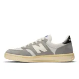 Championes New Balance T500 unisex, color gris y blanco, con detalles en negro. Confeccionados en ante y nobuk de piel de cerdo, con detalles perforados en la puntera y entresuela de goma.