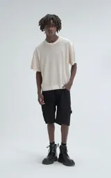 Remera de tejido de punto color beige con moldería ligeramente oversize, cuello redondo y mangas cortas. Confeccionada en una mezcla de viscosa y poliéster que ofrece una caída fluida y textura suave.