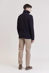 Sweater de punto color crema con cuello alto y cierre de cremallera parcial. Diseño de corte holgado y mangas largas.