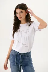Remera blanca con estampado de moldes de costura en color marrón.