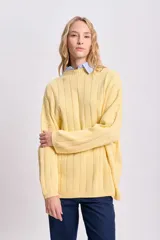 Sweater de punto tejido color amarillo, de corte holgado y cuello alto.
