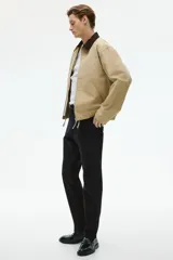 Pantalón negro de corte slim fit, confeccionado en sarga elástica de algodón. Cuenta con cierre y botón, bolsillos al bies y bolsillos insertados atrás con botón.