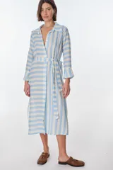 Vestido camisero largo a rayas horizontales verdes y blancas, con cuello clásico, mangas 3/4 y abertura frontal con botones. Confeccionado en lino.