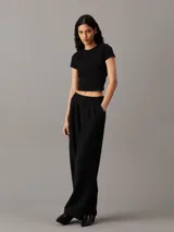 Remera negra de algodón, corte slim cropped, cuello redondo y mangas cortas.