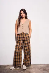 Chaleco de punto sin mangas, color camel jaspeado, con escote en V y cierre frontal de tres botones marrones.